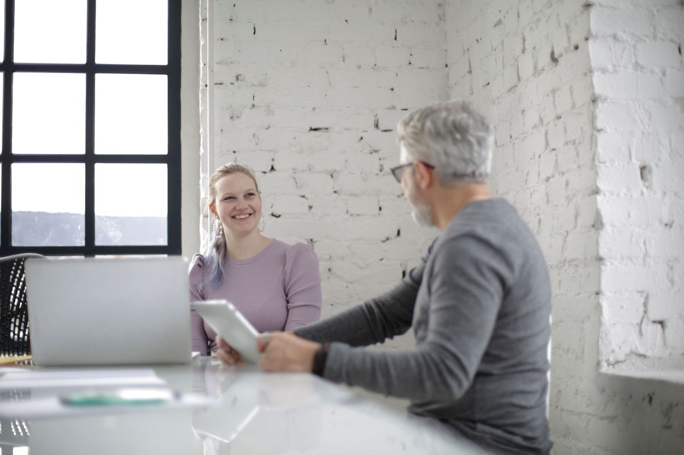 Twee collega’s voeren aan tafel een gesprek en luisteren naar elkaar.