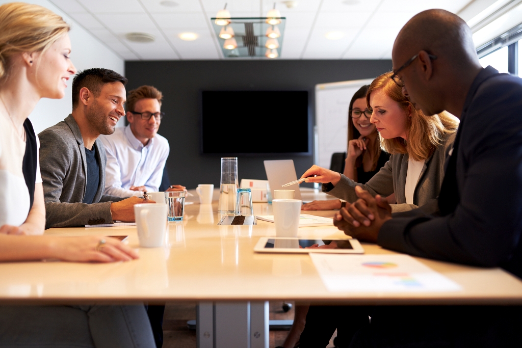 Een team overlegt samen rond een tafel over de ontwikkeling van hun organisatie