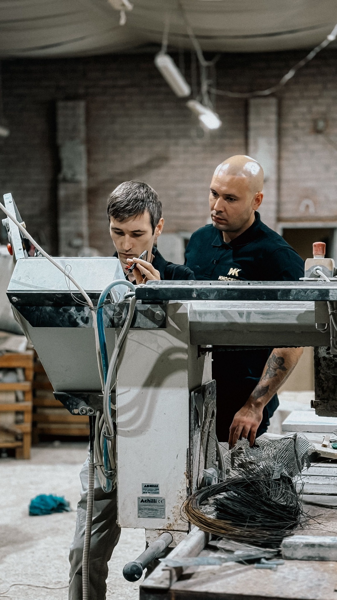 Twee collega’s bij een technische handeling in een werkplaats.